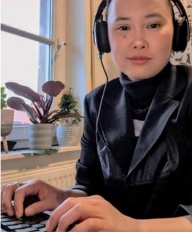 Estrella Bruex wearing headphones at her laptop